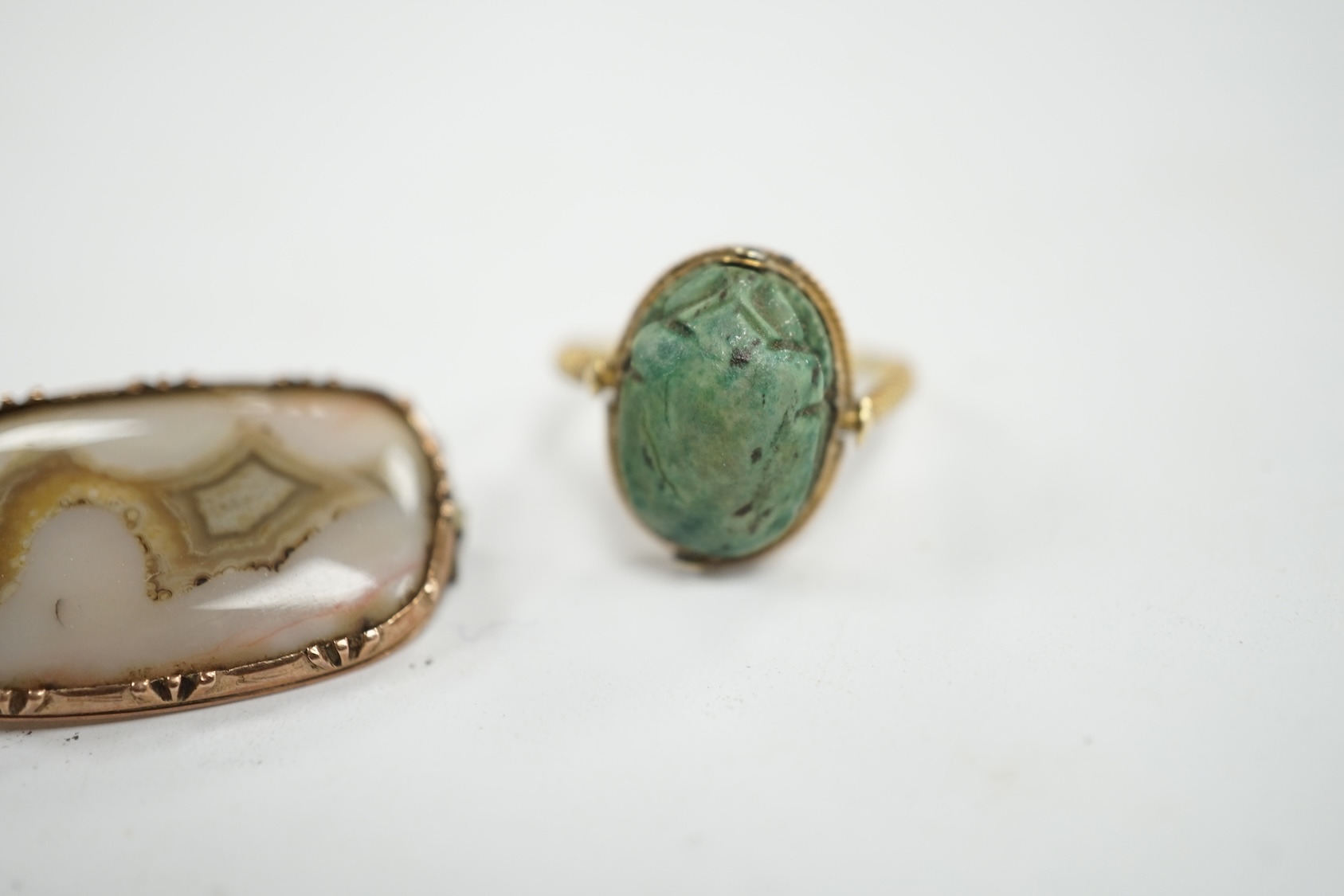 An antique yellow metal 'Scarab' ring and a banded agate set brooch. Condition - poor to fair